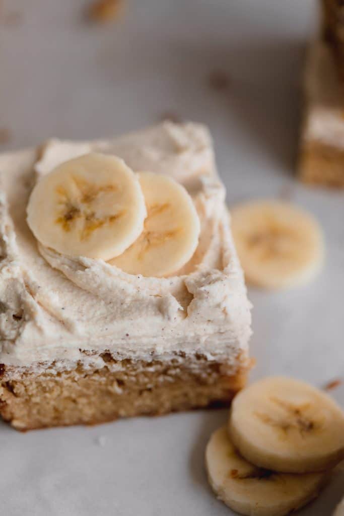 banana bars with brown butter frosting and sliced bananas on top