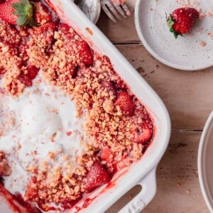 Strawberry Crumble topped with ice cream in a baking dish.