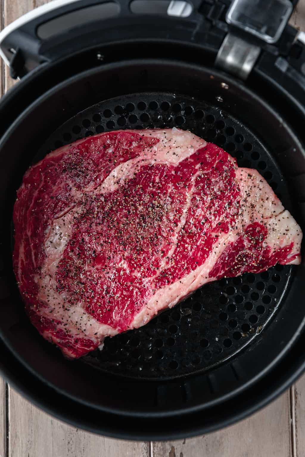 ribeye steak in the air fryer basket