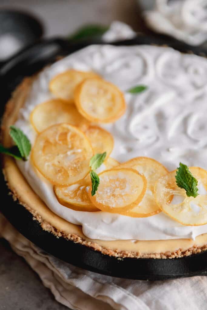 creamy lemon pie topped with whipped cream and candied lemon