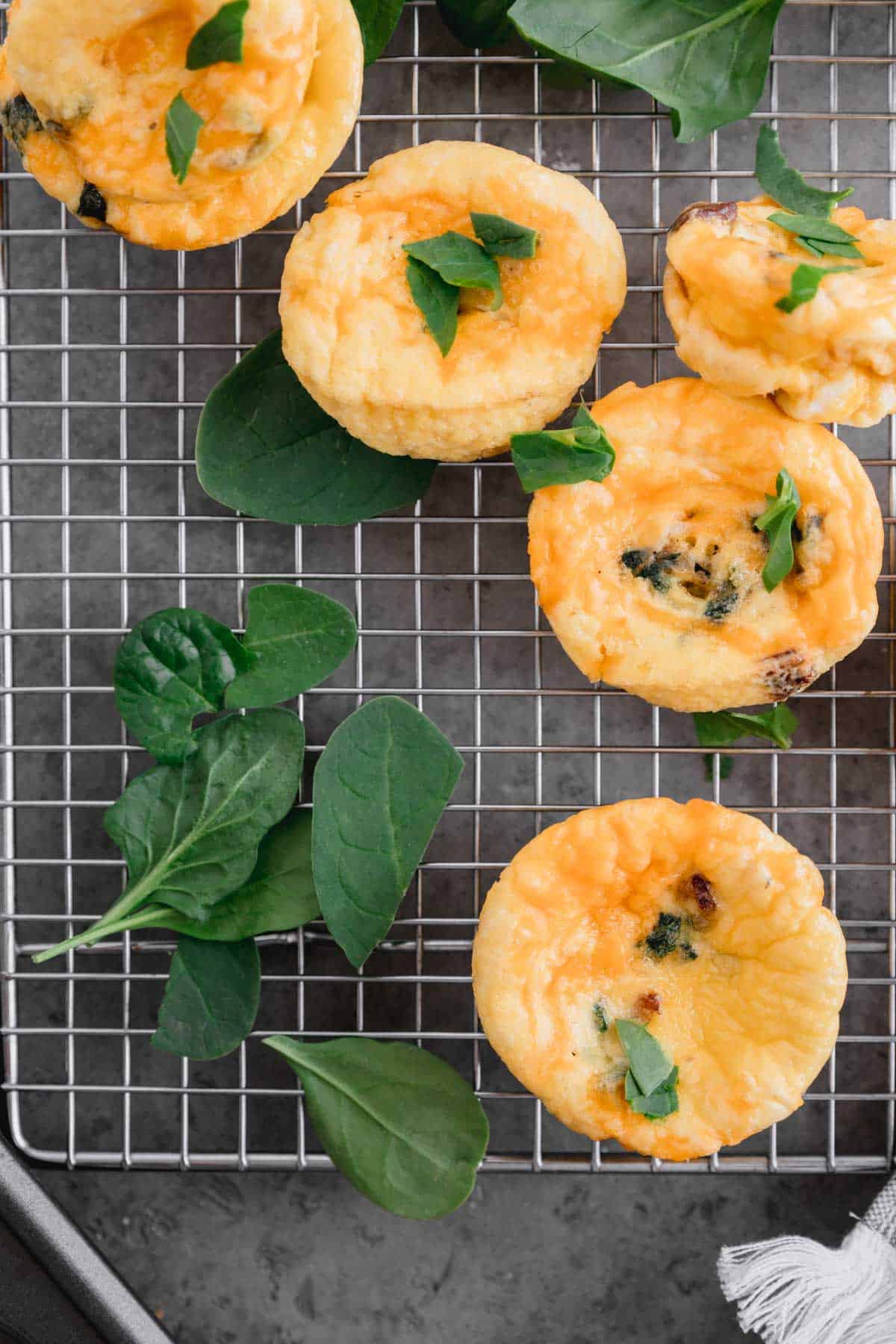 Egg Bites with Boursin Cheese and spinach on a cooling rack. 
