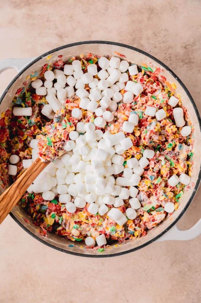 marshmallows being folded into the fruity pebbles mixture