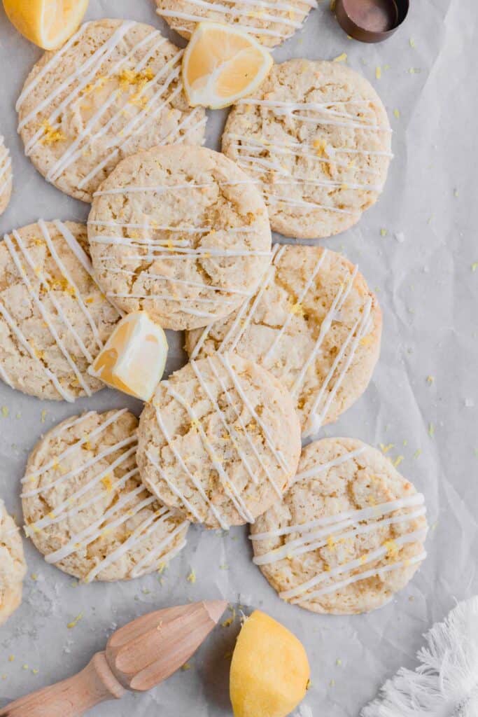 lemon ricotta cookies stacked with lemon drizzle and lemon wedges