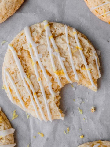 Lemon Ricotta Cookie topped with lemon frosting that has a bite taken out of it.