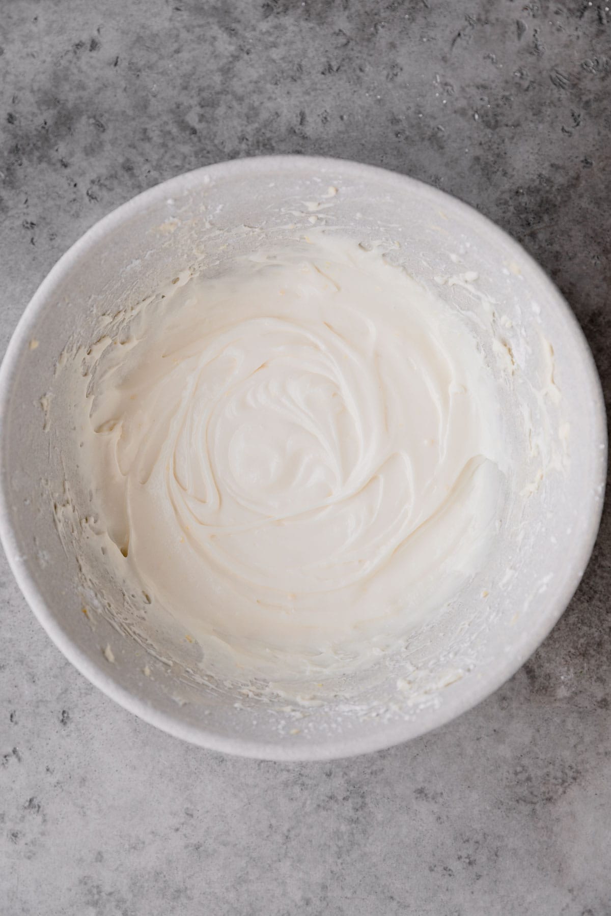 Lemon cream cheese frosting mixed up in a large mixing bowl. 