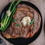Juicy Air Fryer Ribeye Steak with compound butter and asparagus.
