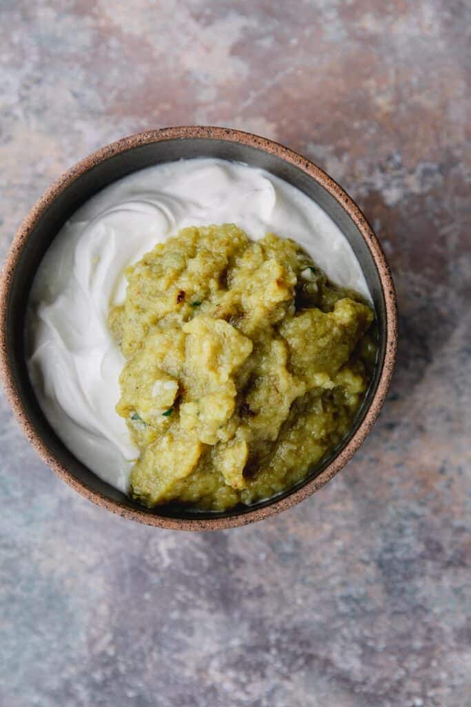 Salsa verde and sour cream in a bowl.