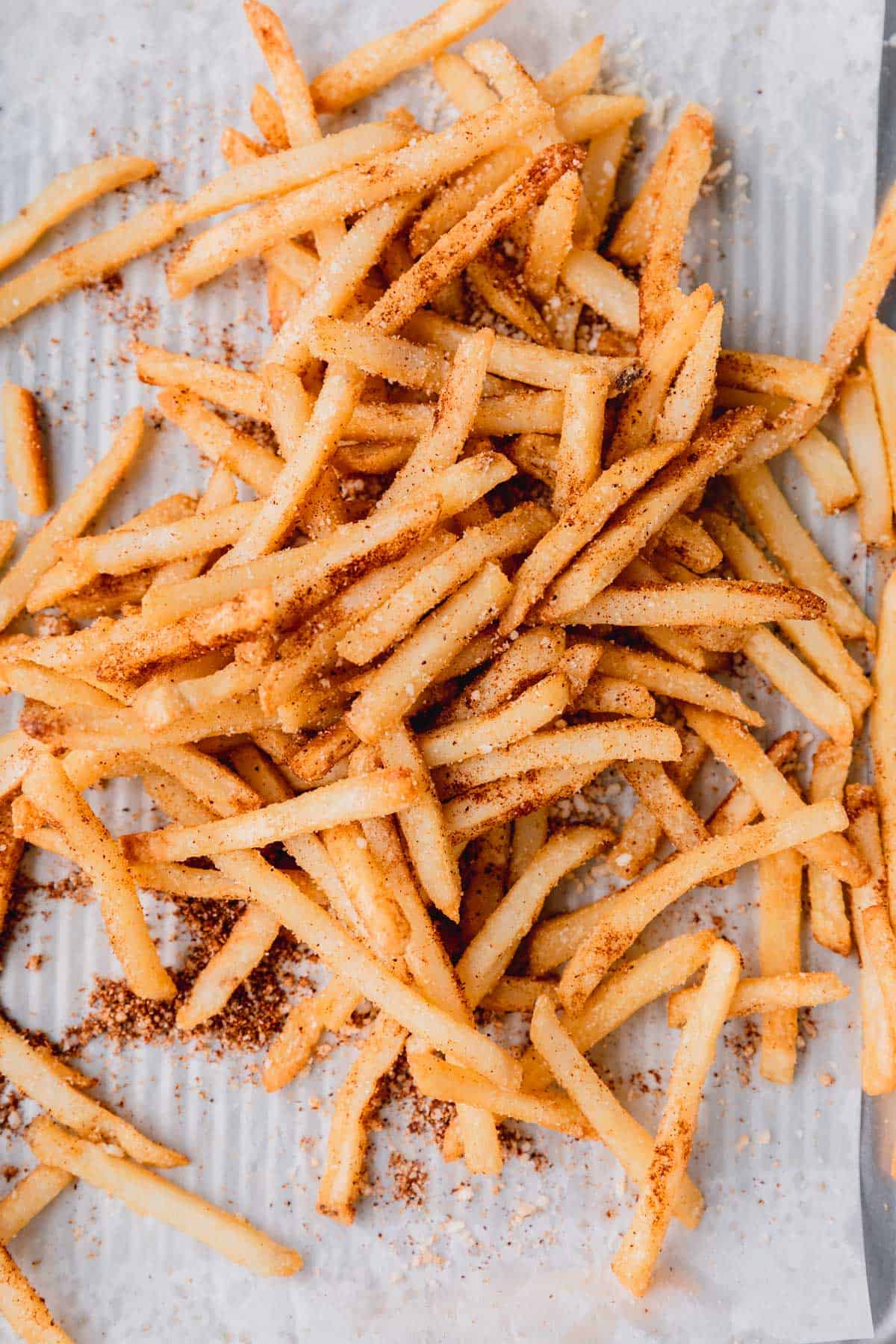 Seasoned fries on a sheet tray. 