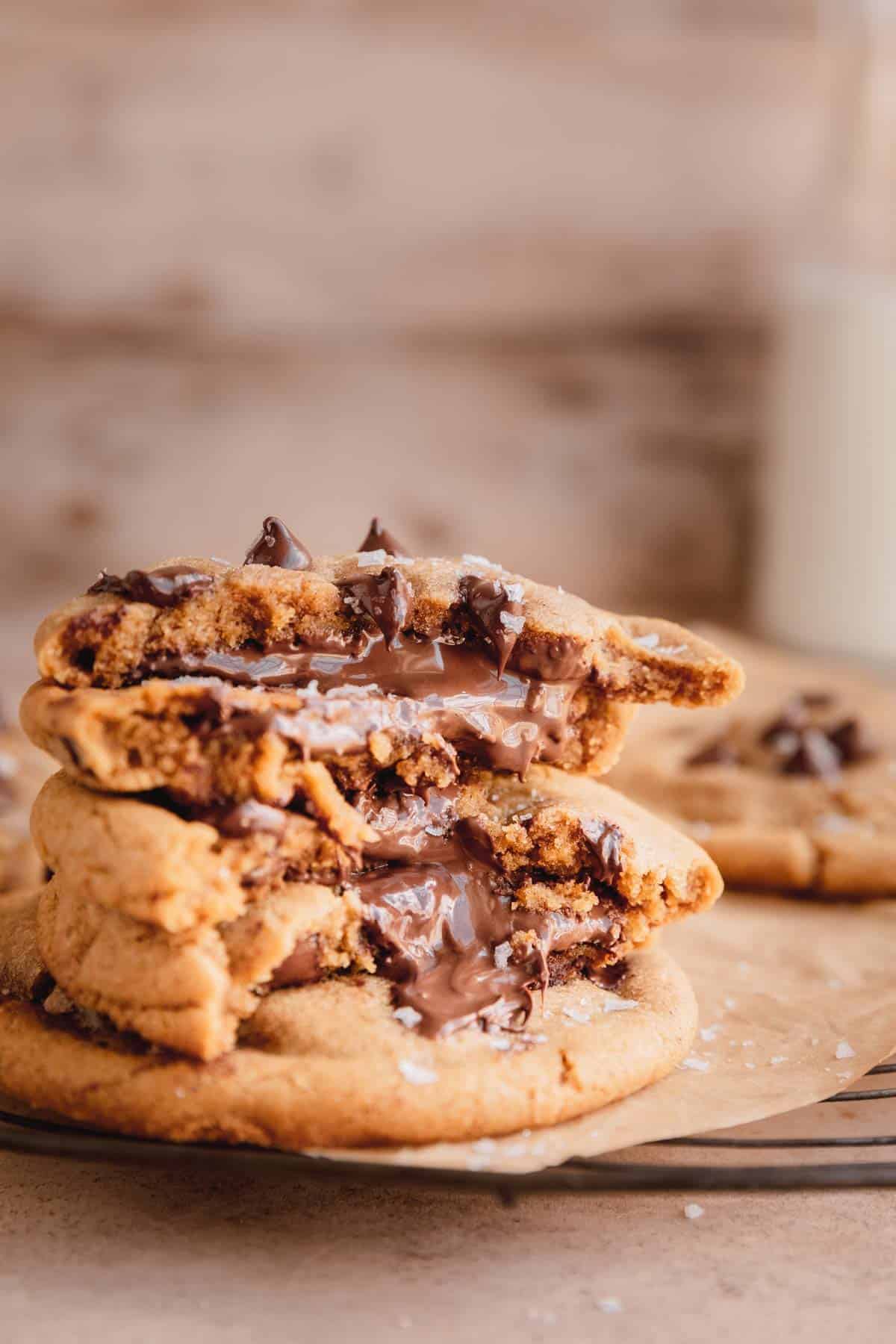 Chocolate chip cookies stuffed with Nutella, broken in half to see the inside. 