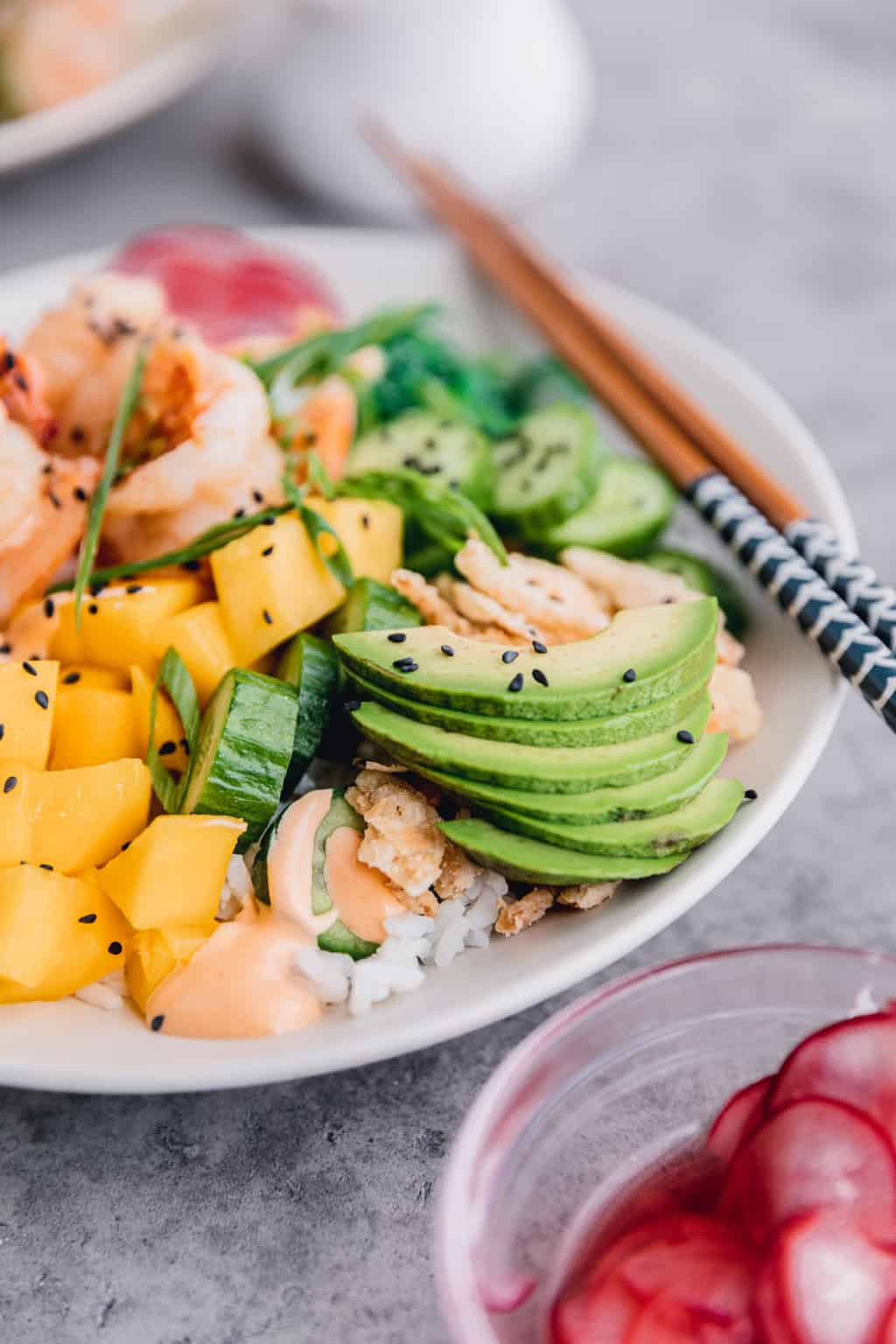 Avocado slices, mango and cucumber in the rice bowl. 