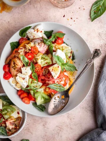 easy heirloom tomato salad in a bowl with a serving spoon