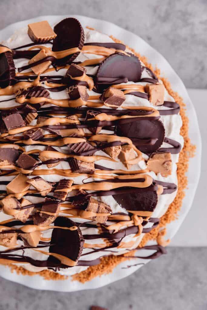 easy Reese's peanut butter cups pie recipe topped with peanut butter cups, chocolate and peanut butter drizzle