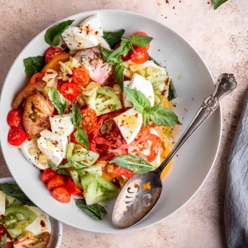 easy heirloom tomato salad in a bowl with a serving spoon