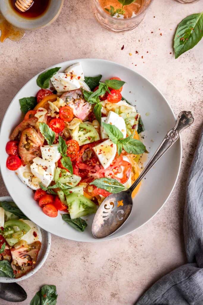 easy heirloom tomato salad in a bowl with a serving spoon