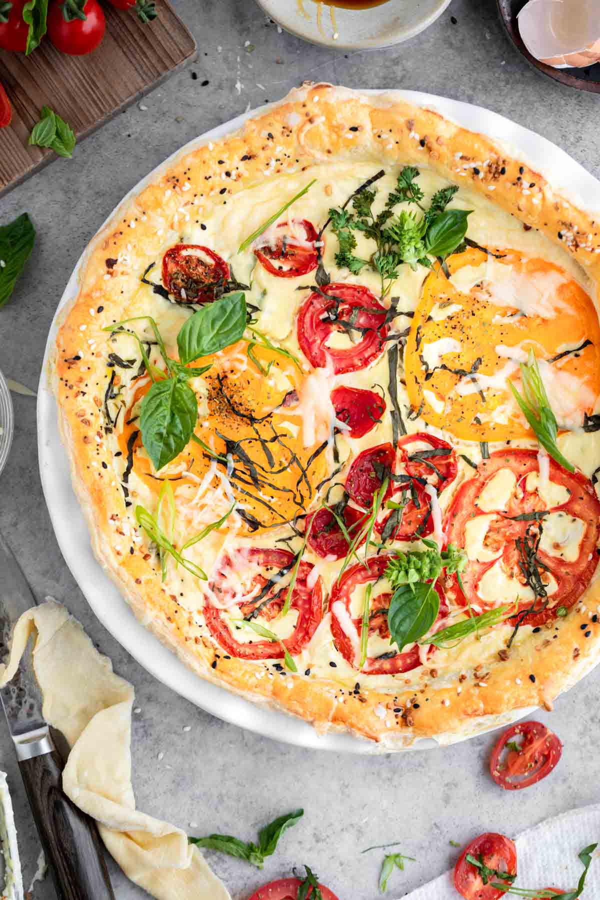 Easy tomato pie with no mayo, topped with basil.