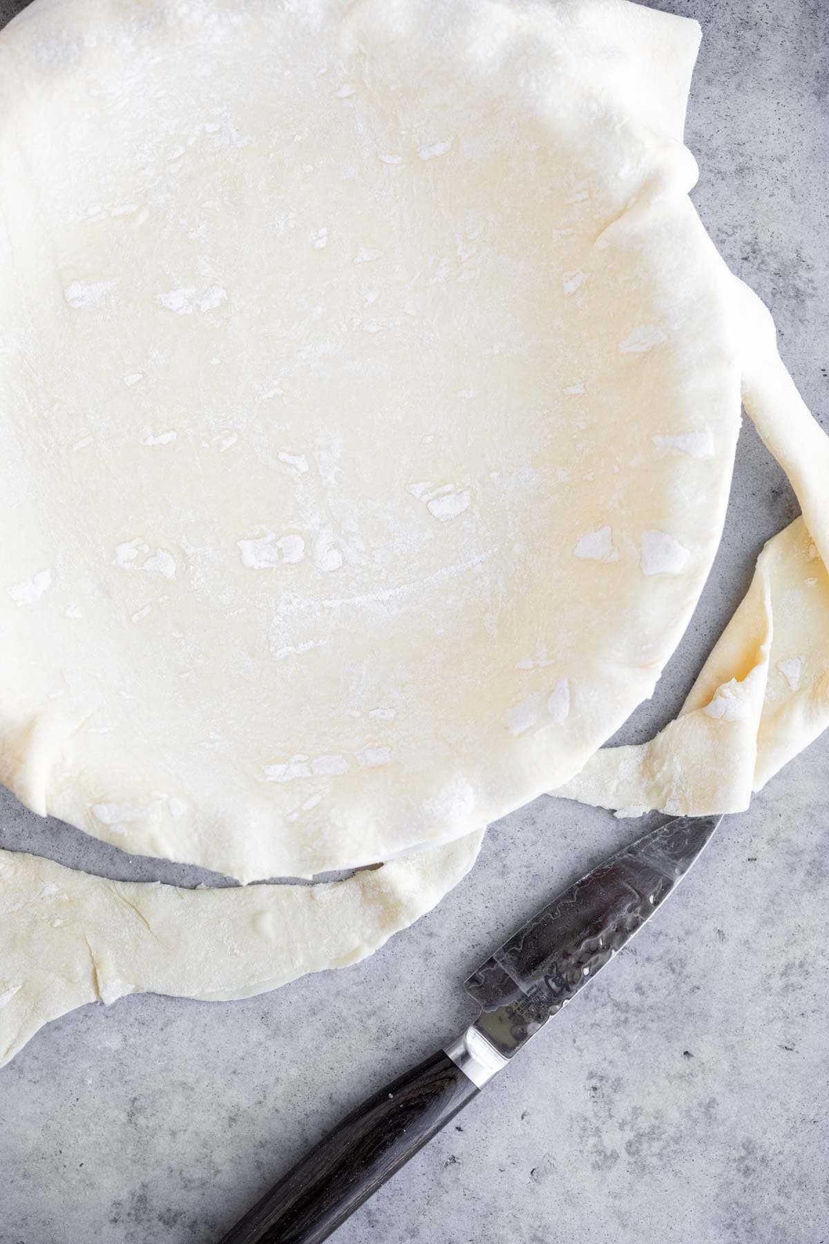 Raw puff pastry dough in a pie pan.