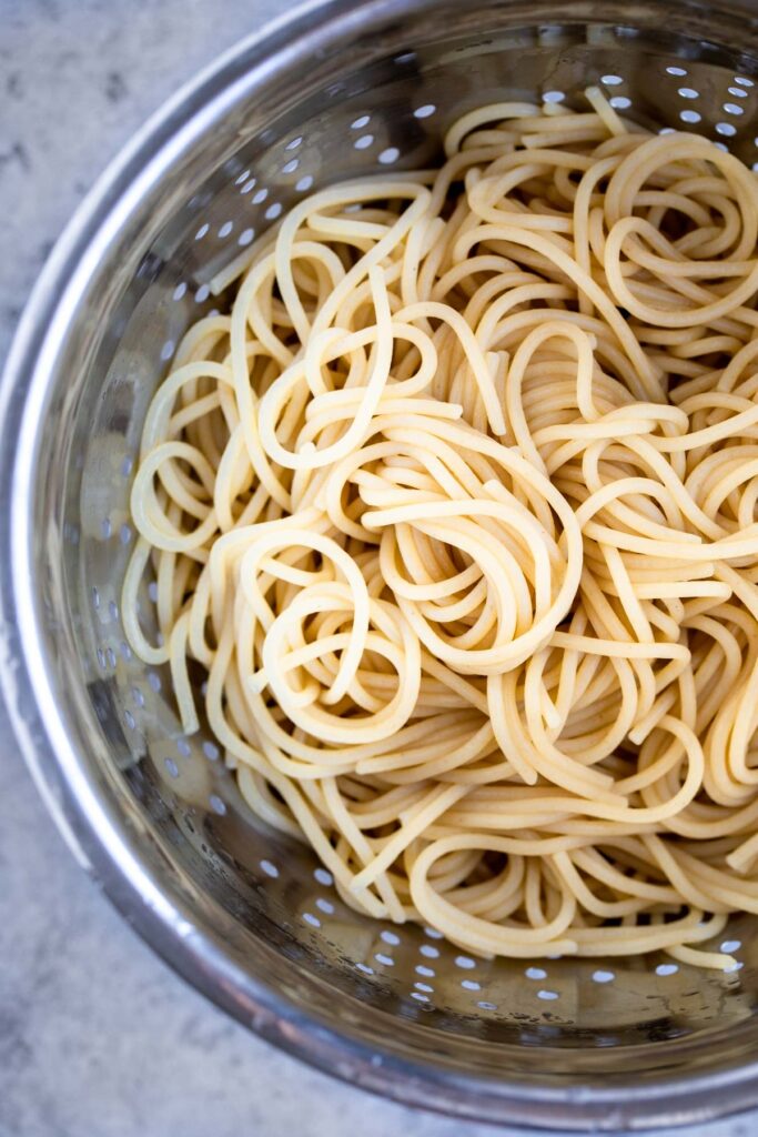Drained spaghetti noodles.