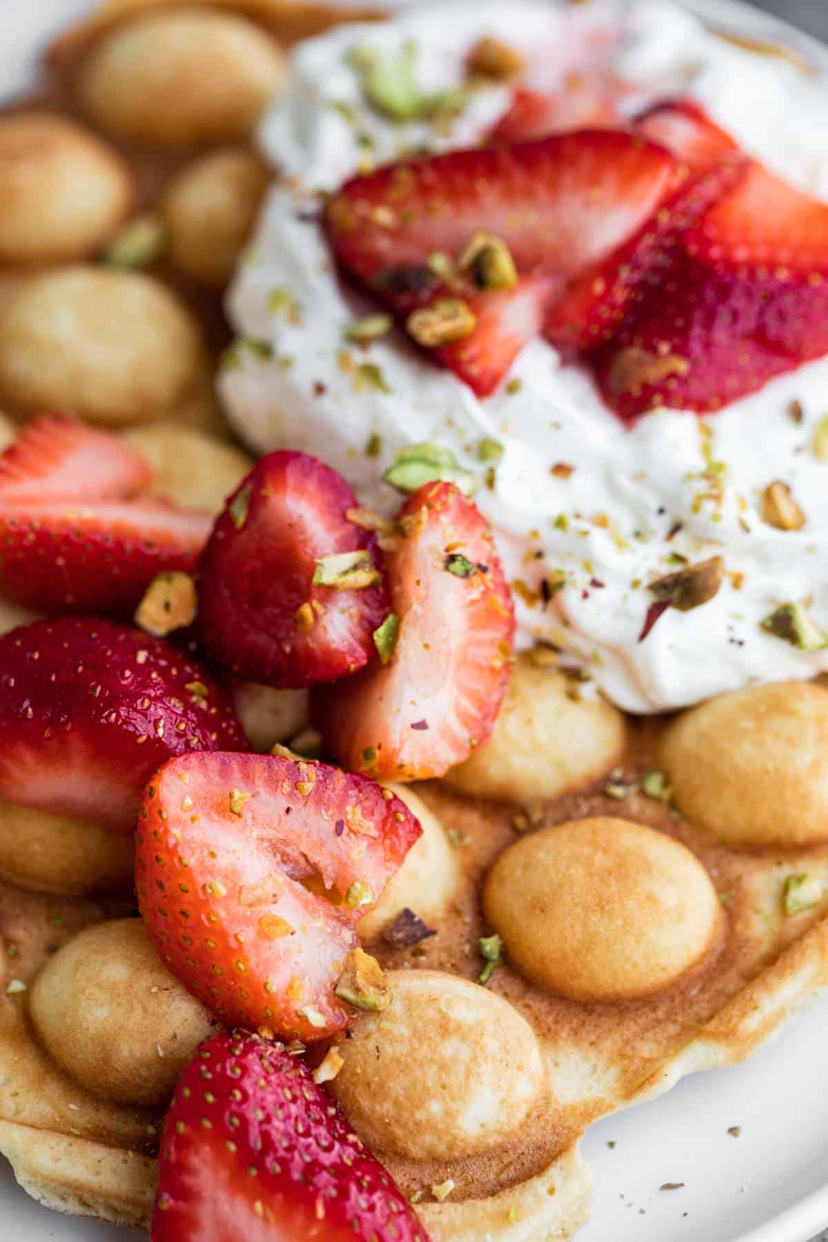 Bubble Waffles with strawberries, cream and pistachios.