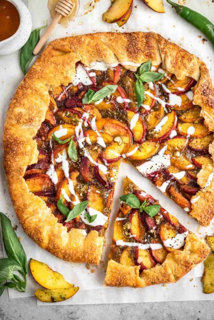 A spicy peach galette with one slice cut from it.