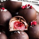 chocolate covered cherries stuffed with Nutella on a plate. One has a bite taken out of it so you can see the center.