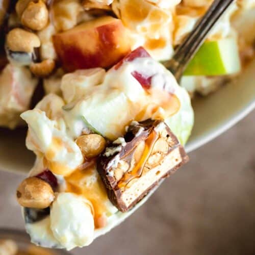 taffy apple salad on a spoon with a piece of Snickers and caramel on top