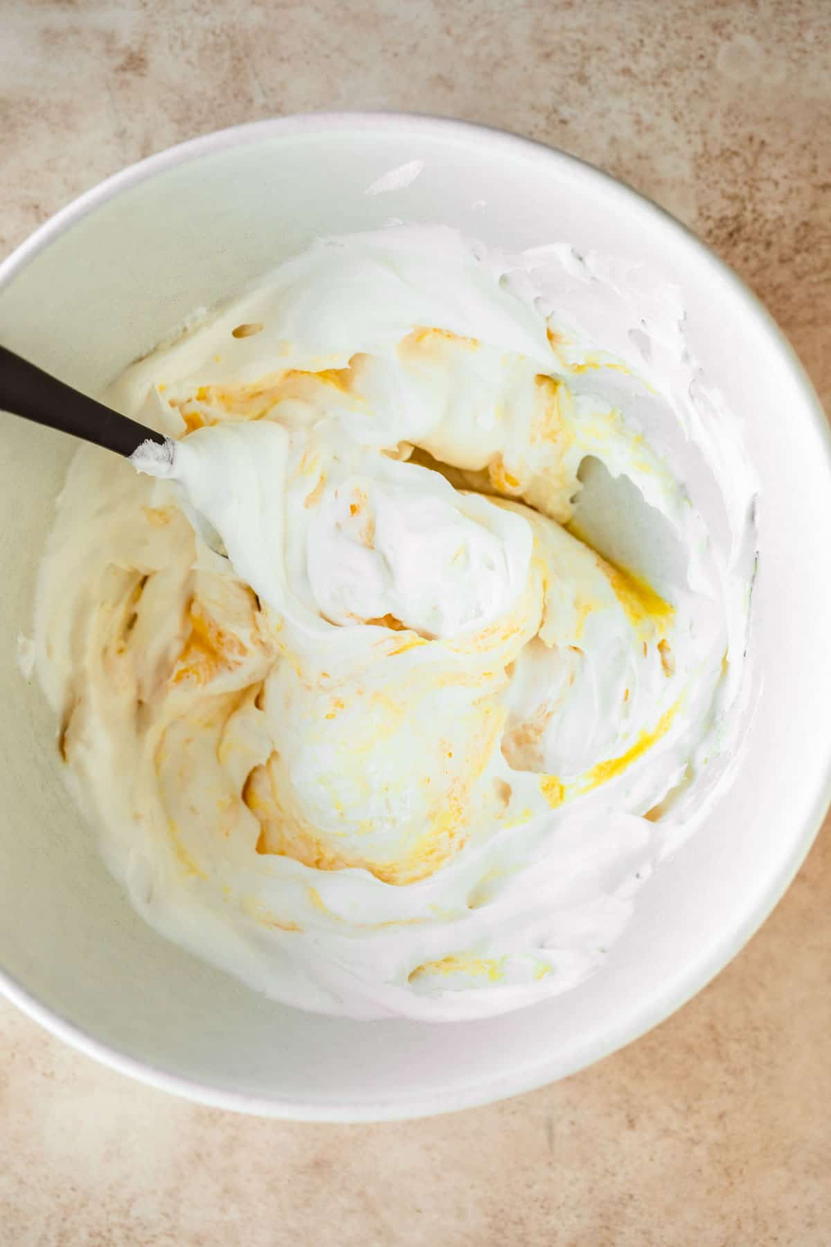 Vanilla pudding, milk and whipped cream mixed together in a bowl. 