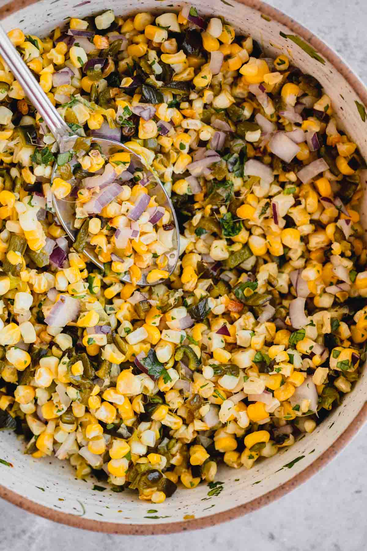 Roasted Chili Corn Salsa in a bowl with a spoon.