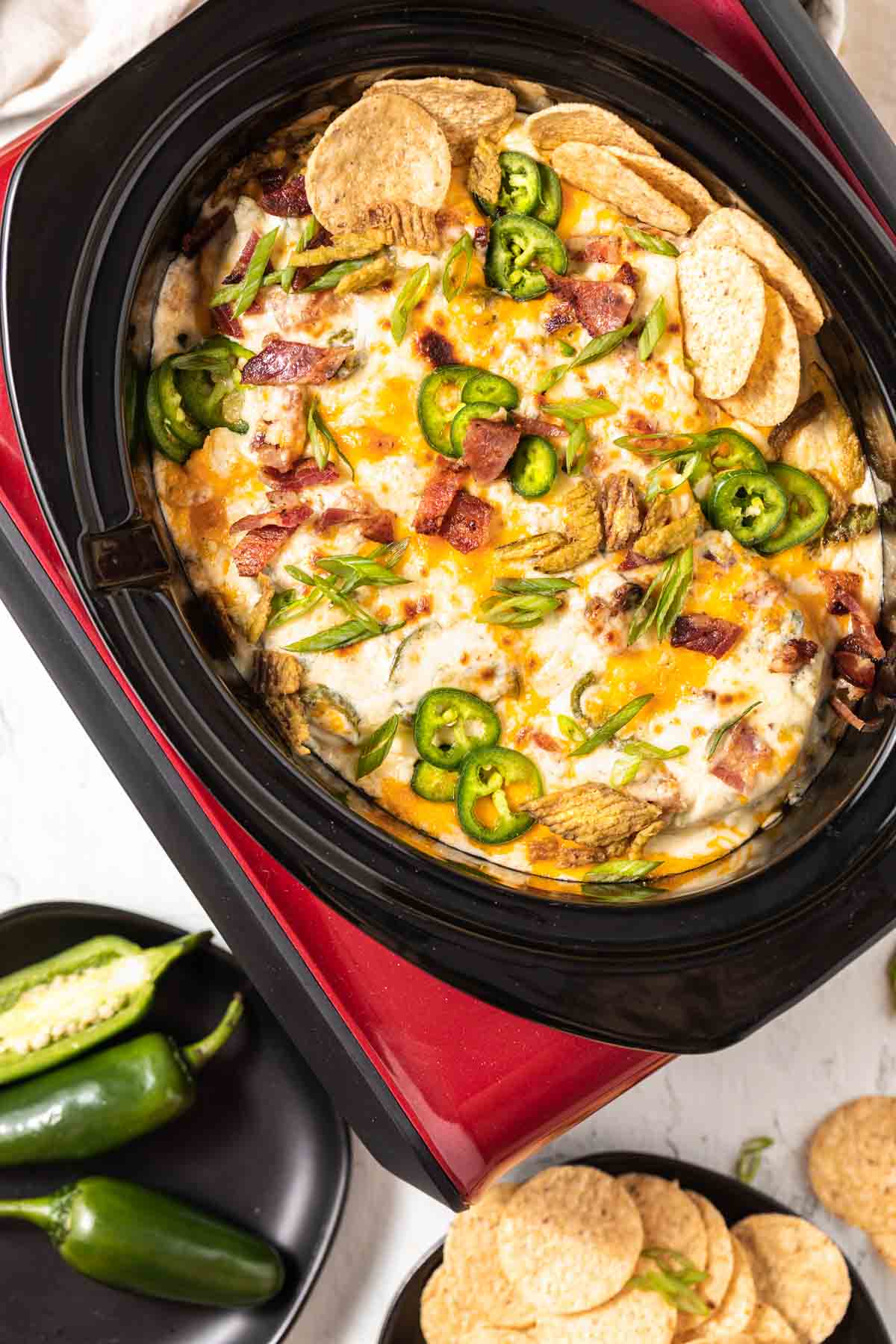 Jalapeno Popper Dip in a crockpot with chips on the side.