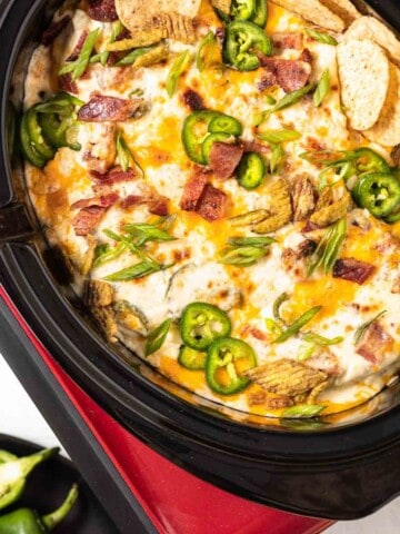 Jalapeno Popper Dip in a crockpot with chips.