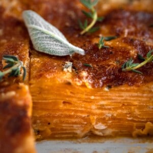 Sweet Potato Au Gratin with a slice out so you see the layered potatoes with sage.