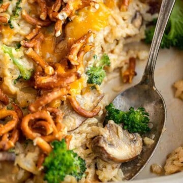 A spoon scooping out a mushroom and broccoli from the casserole.