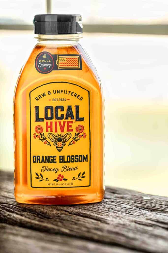 Local Hive Honey bottle on a wooden table. 