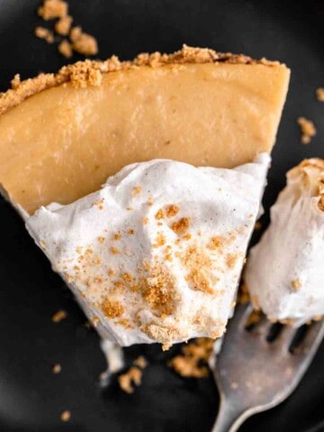 A slice of Butterscotch Cinnamon Pie with whipped cream on top.