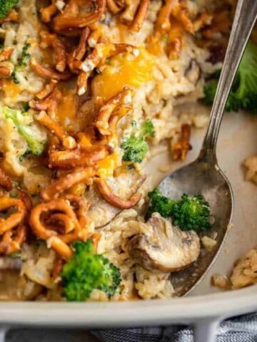 A spoon scooping out a mushroom and broccoli from the casserole.