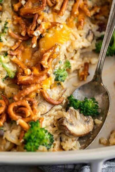 A spoon scooping out a mushroom and broccoli from the casserole.