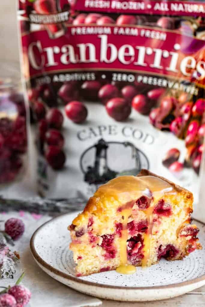 A slice of cake in front of a bag of Cape Cod Select Cranberries.