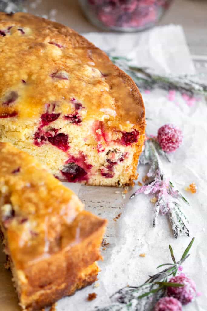 Cranberry cake with a slice taken out of it.