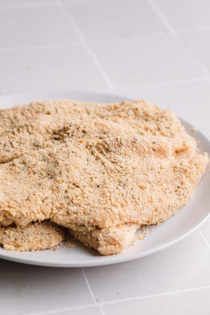 Raw breaded chicken on a plate. 