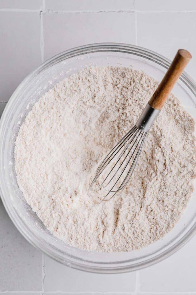 Dry ingredients whisked together in a bowl. A whisk sitting in the bowl.
