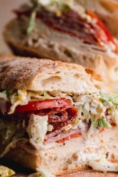 Close up of the sandwich with the Italian meats, provolone, tomato and lettuce salad.