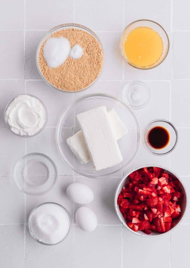 Recipe ingredients for mini cheesecake recipe: cream cheese, sugar, butter, graham cracker crumbs, vanilla, strawberries, lemon juice, eggs.