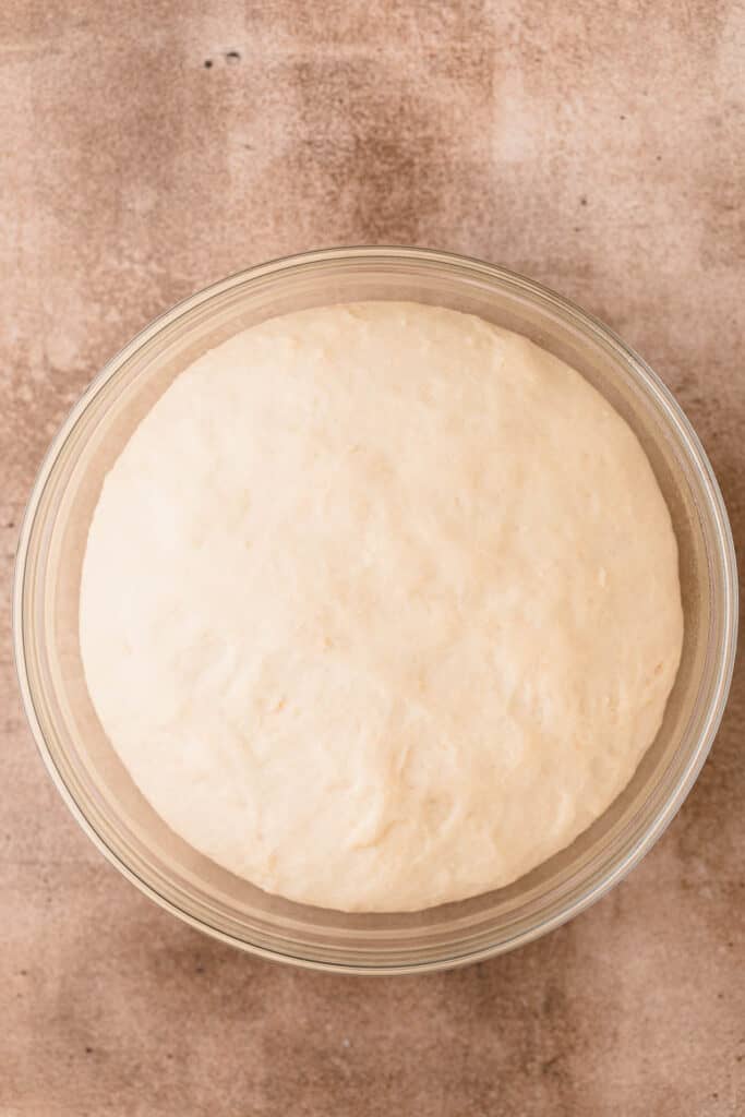 The proofed dough in a glass bowl. 
