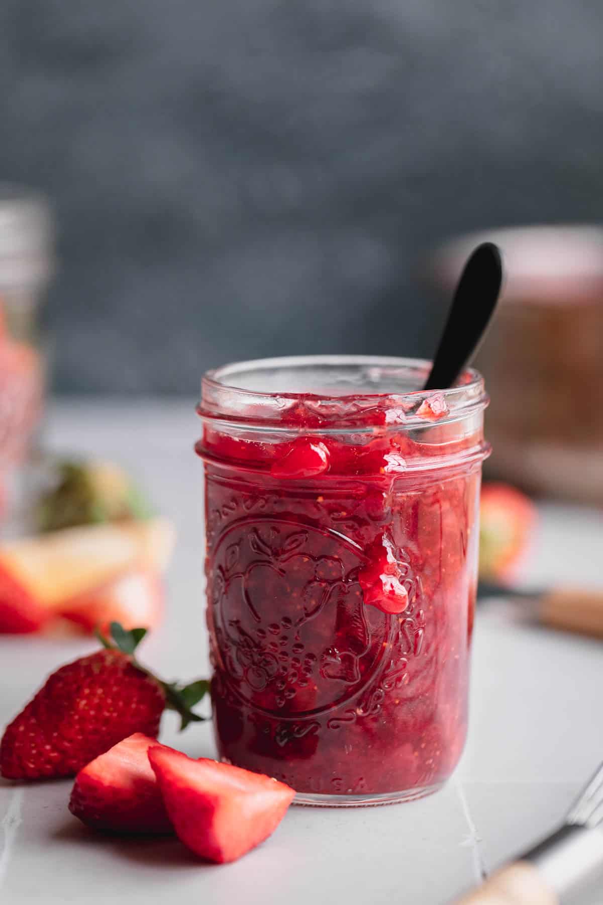 Strawberry Compote in a Mason jar with a small spoon in it. 