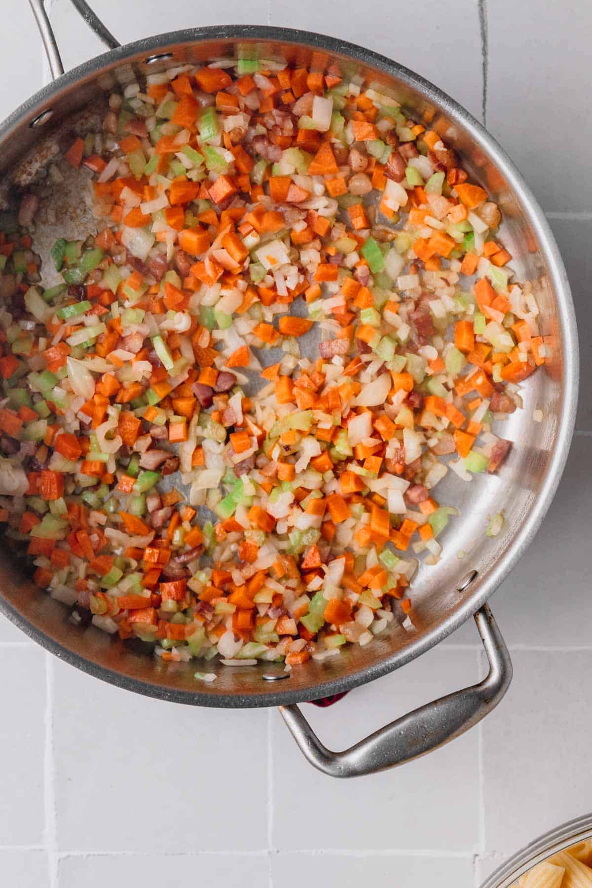 Onion, celery and carrot cooking in a pan.
