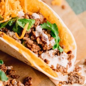Hard taco shell filled with taco ground beef, spicy ranch, cheese and lettuce, wrapped in a flour tortilla.
