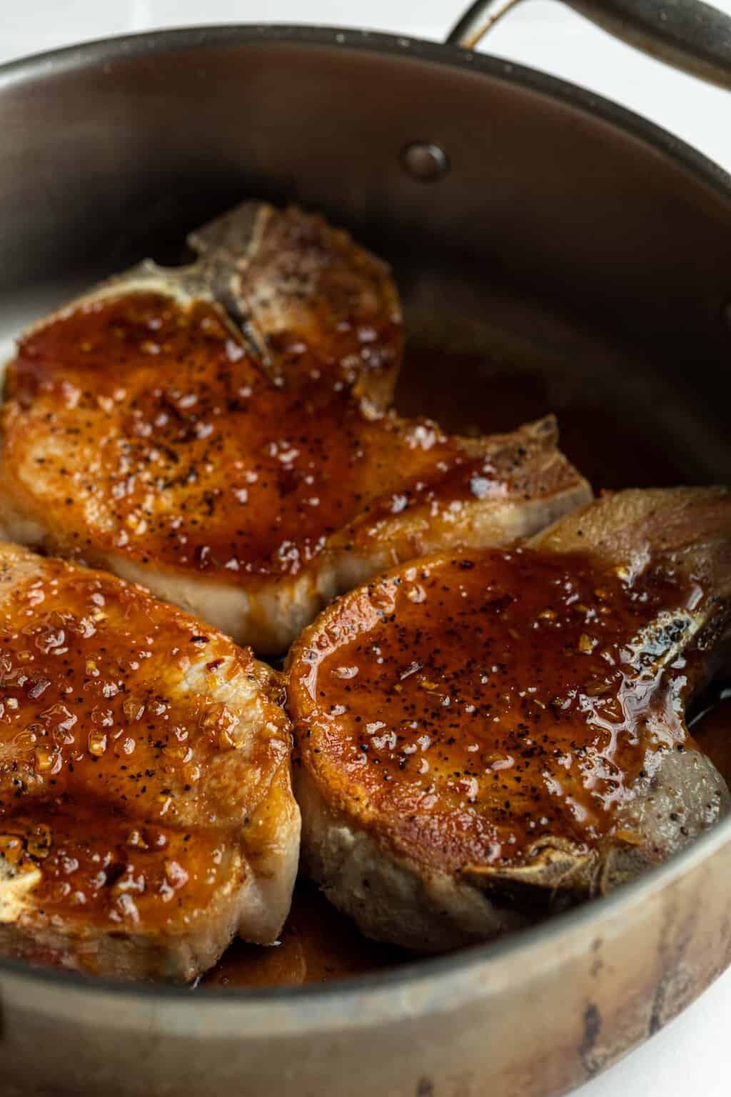 Honey garlic sauce on top of the meat in a pan. 