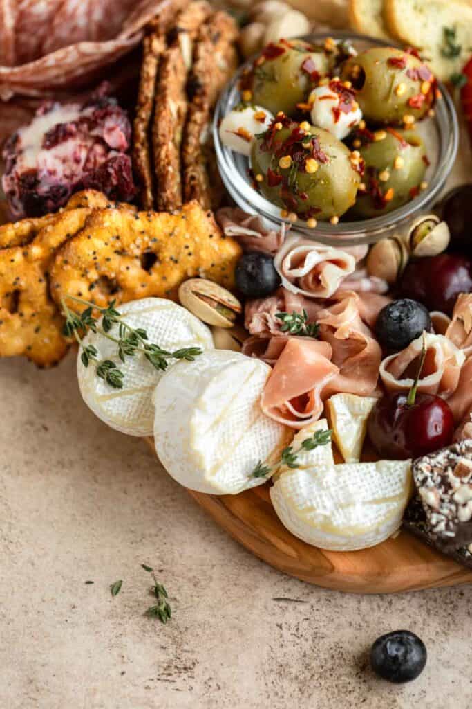 A small charcuterie board with the best cracker selection, cheese, olives and fruit.