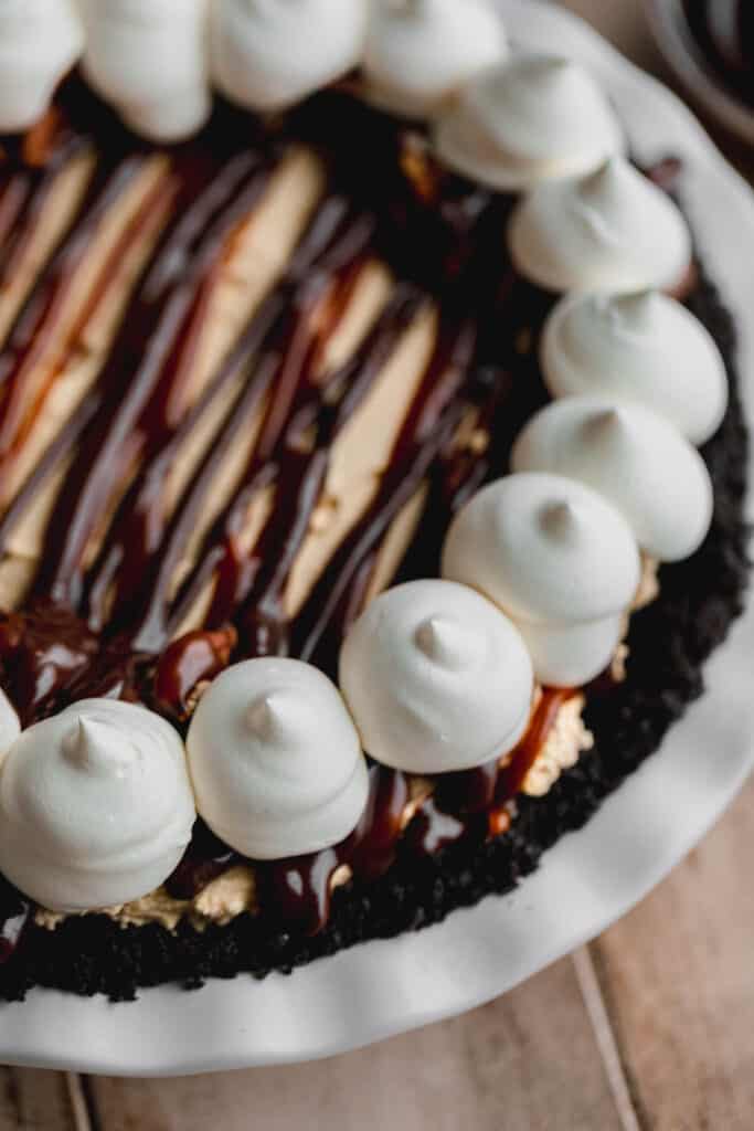 Turtle pie decorated with chocolate, caramel and whipped cream.