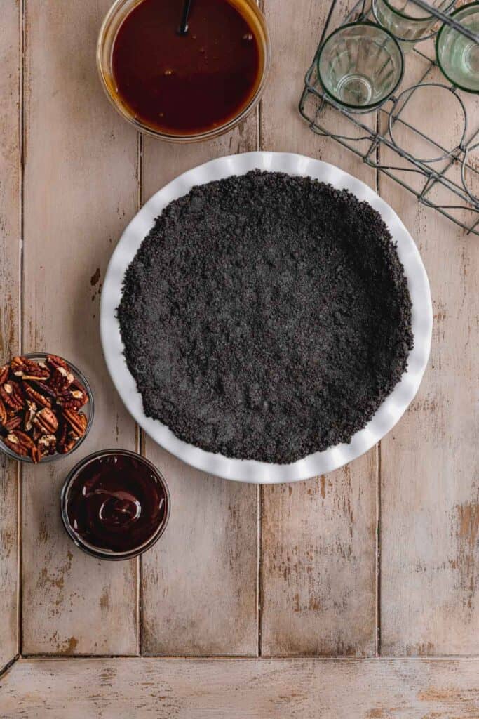 Oreo cookie crust pressed inside a white pie dish.