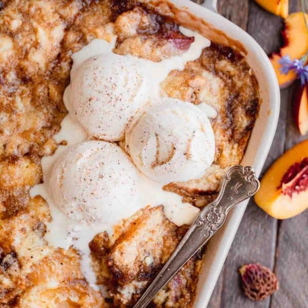 Peach cobbler with cake mix topped with vanilla ice cream.